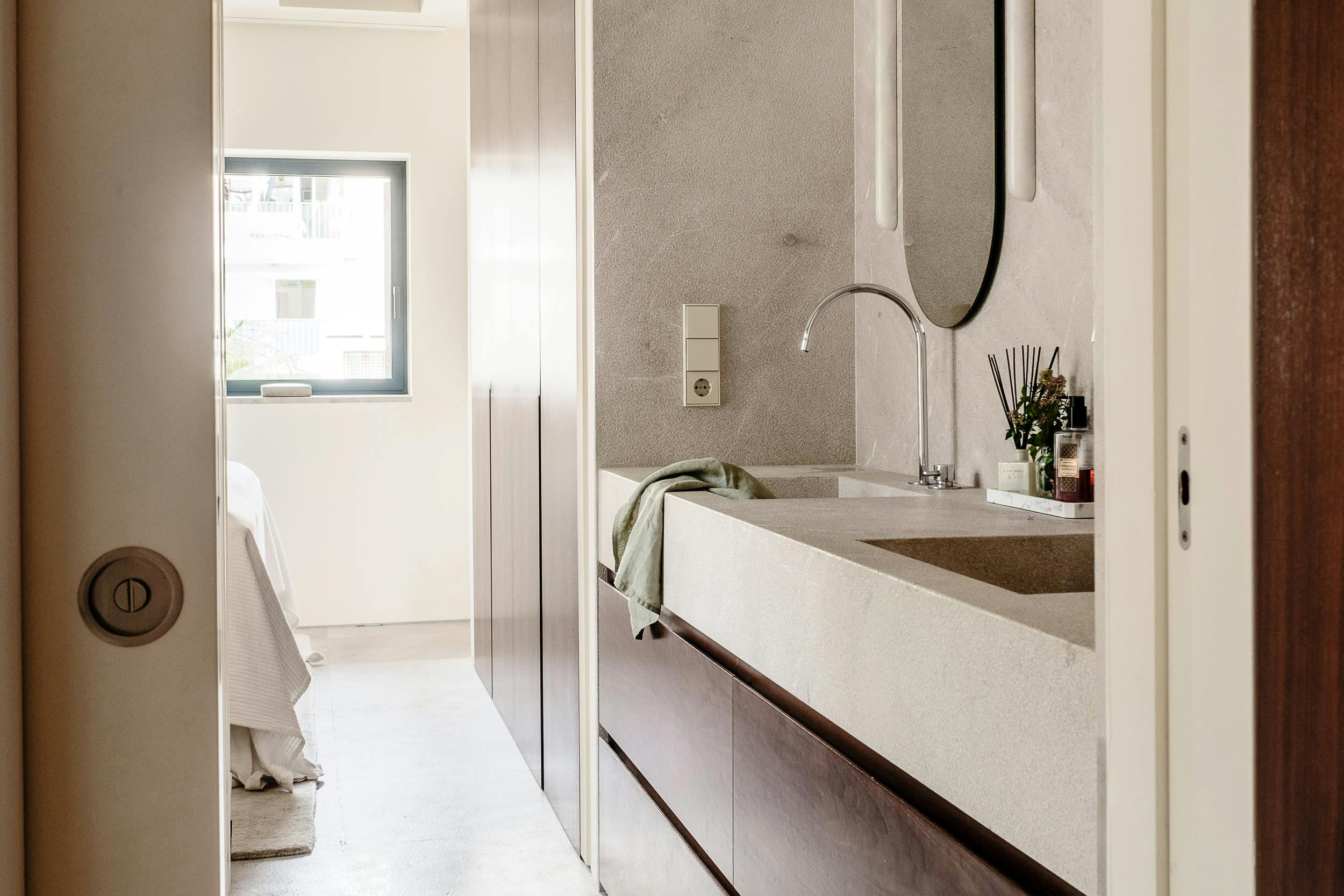 The image features a bathroom with a white sink, a mirror, a window, and a door.